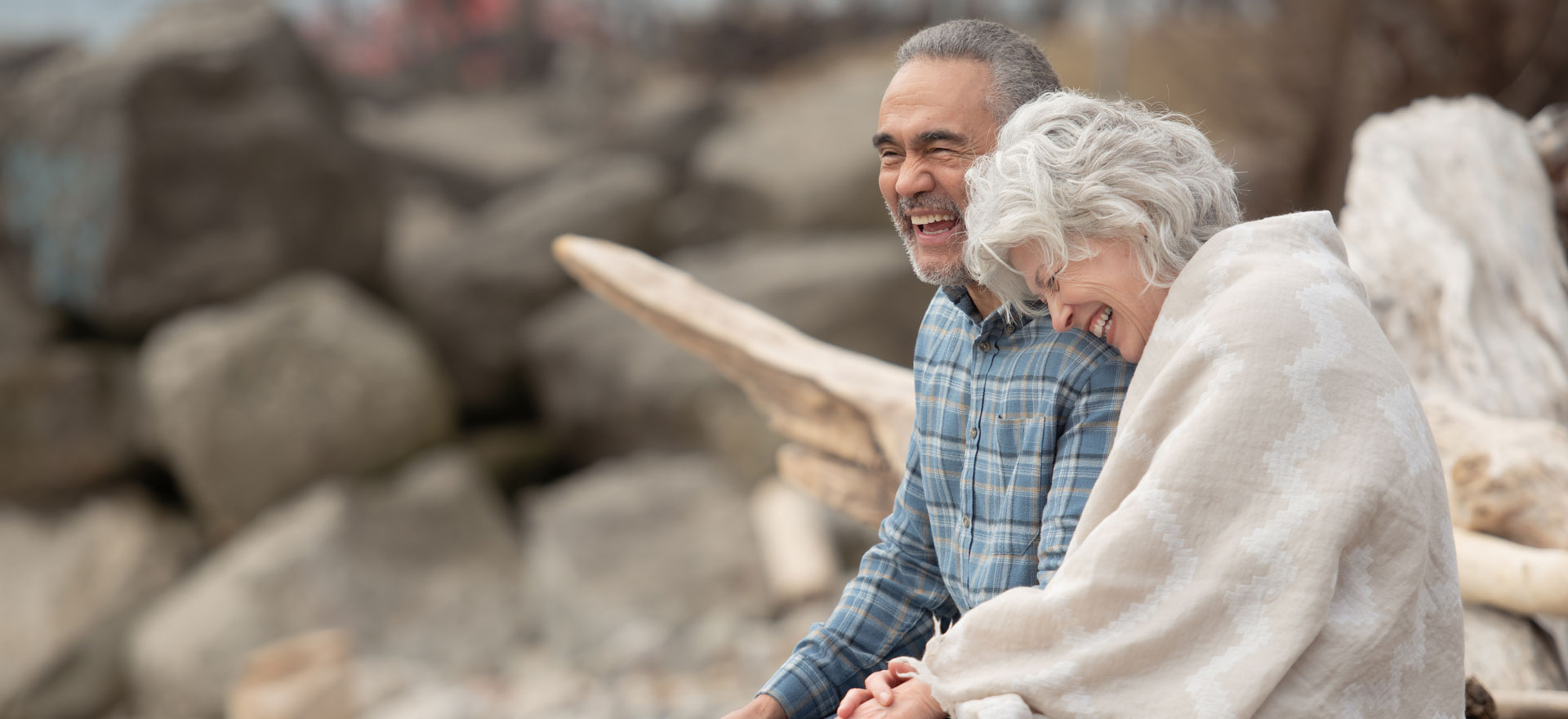 A couple sitting on a bench at a beach