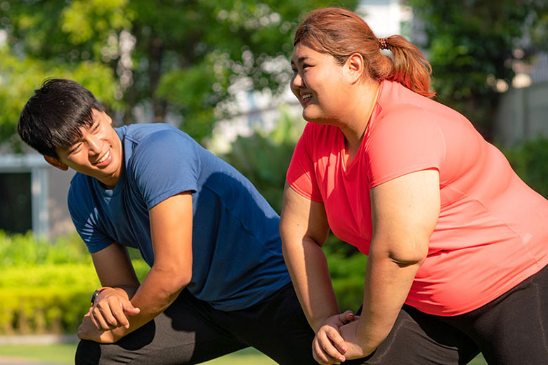 Woman exercising with trainer outdoors